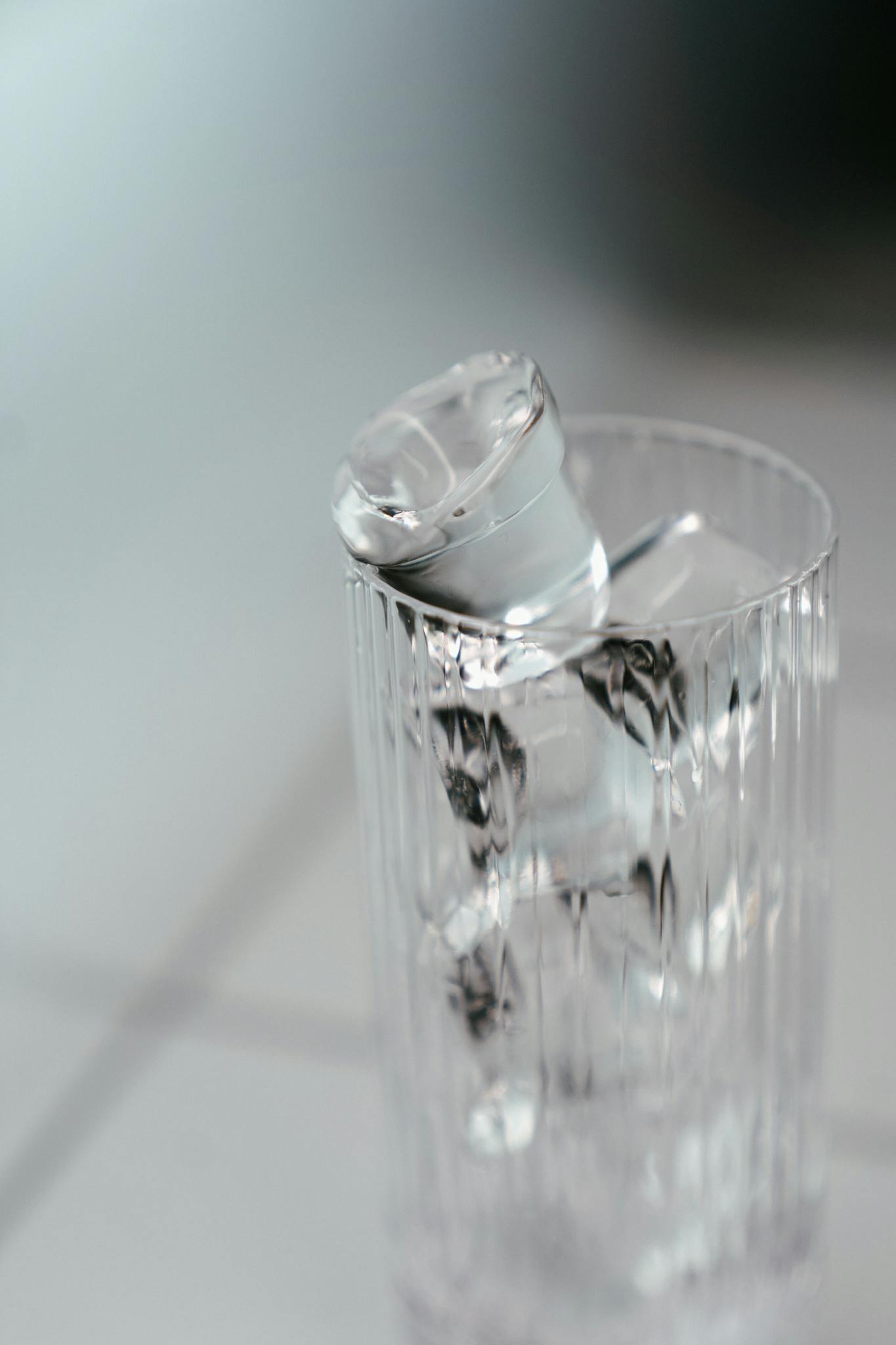 Detailed shot of ice cubes in a clear glass with a textured design, offering copy space.