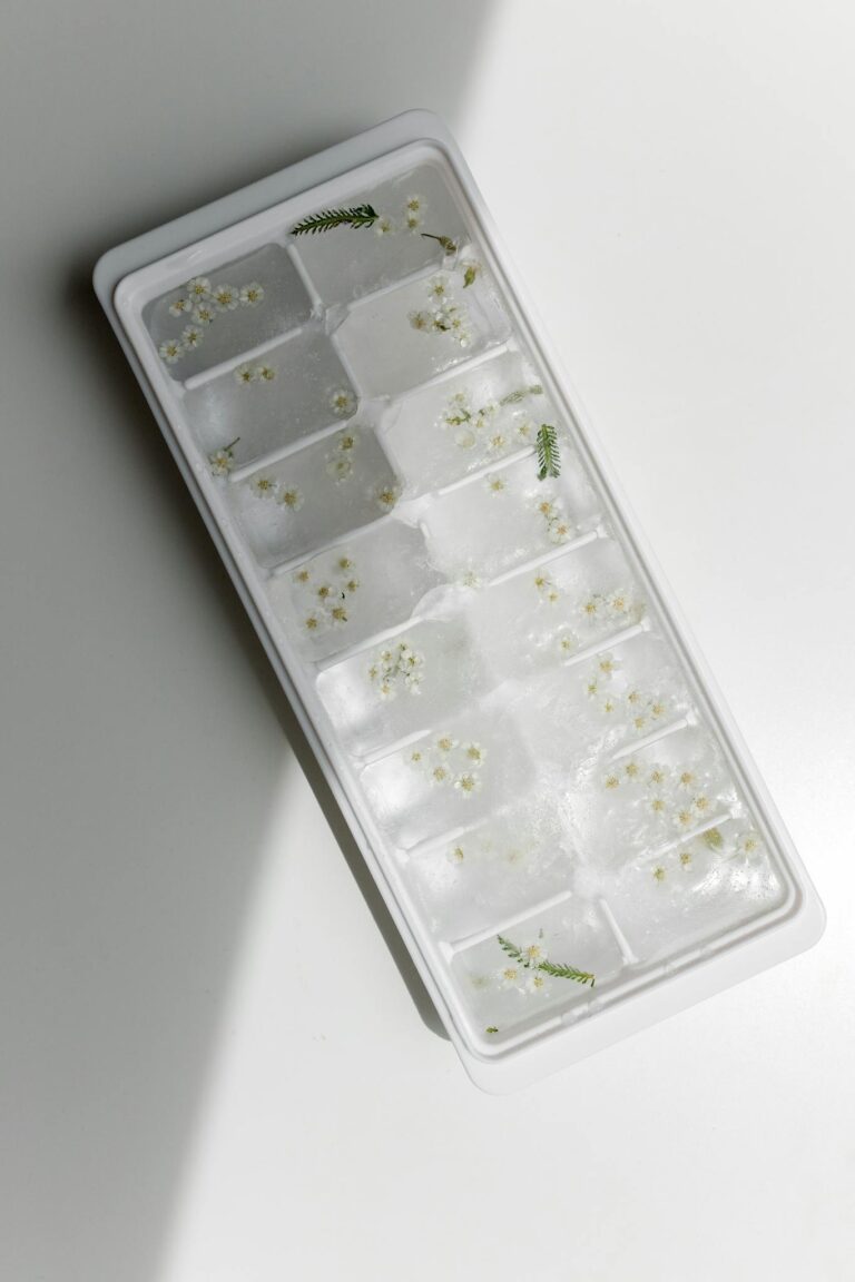 Minimalist ice cube tray filled with delicate flowers, perfect for artistic culinary designs.